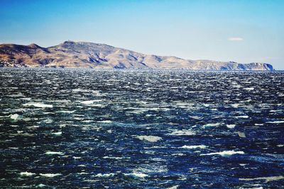 Scenic view of frozen river against clear sky on sunny day