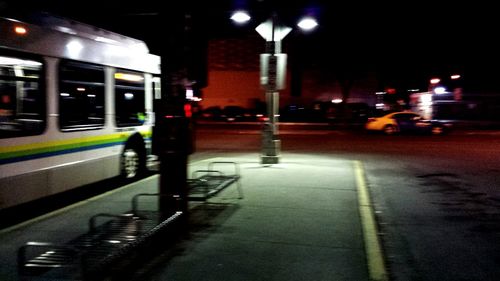 Road passing through illuminated city at night