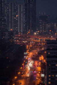 High angle view of illuminated city street and buildings at night