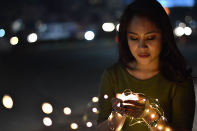 Close-up of woman with illuminated lighting equipment