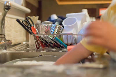 Boy washing container at kitchen sink