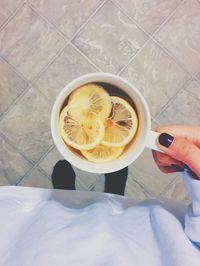 Low section of woman holding lemon tea