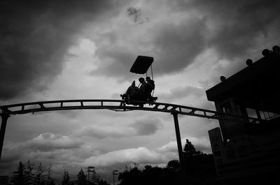 Low angle view of silhouette man on bridge against sky