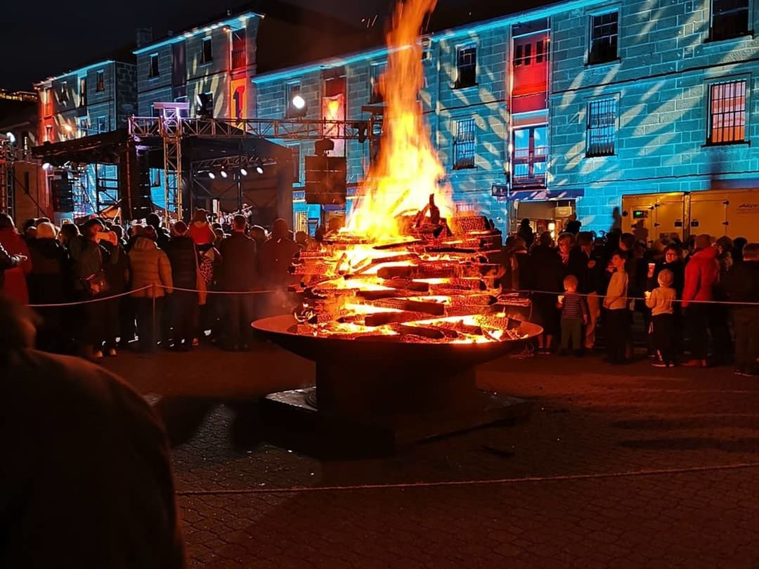 GROUP OF PEOPLE IN FRONT OF FIRE AT NIGHT