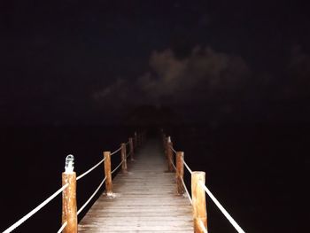 Boardwalk against sky at night