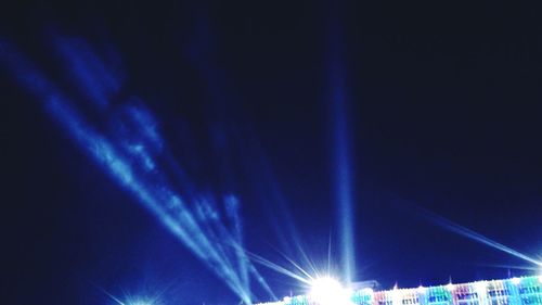 Low angle view of illuminated stage against sky at night