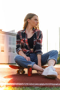 Full length of teenage girl sitting outdoors