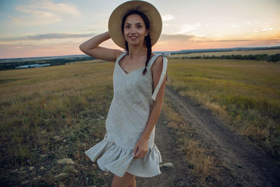 Portrait of young woman standing on field