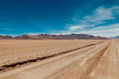 Scenic view of desert against blue sky