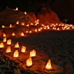 Close-up of lit candles at night