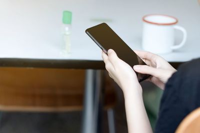 Midsection of man using mobile phone