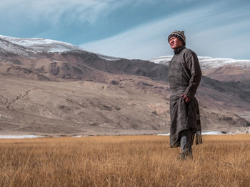 Man standing on field against sky