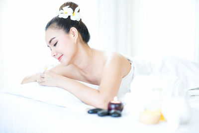 Asian woman on spa bed with fragrant flowers