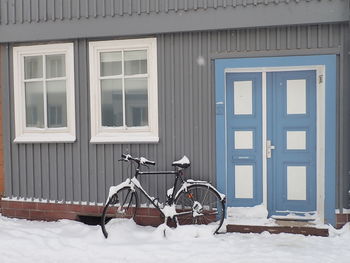 Bicycle against snow covered building