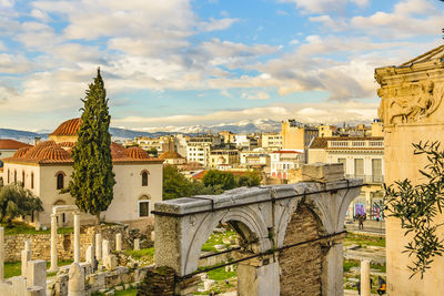 Arch bridge in city against sky