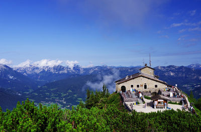 Panoramic view of building and mountains against blue sky