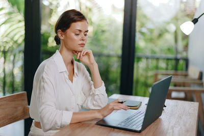 Businesswoman using laptop at table