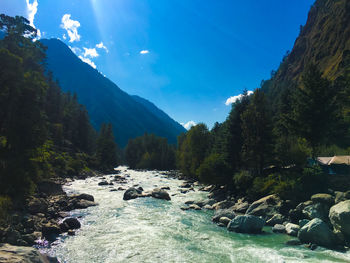 Scenic view of river and mountains against sky