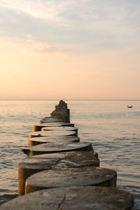 Pier over sea against sky during sunset