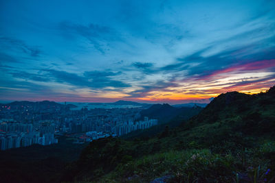 Scenic view of city against sky during sunset