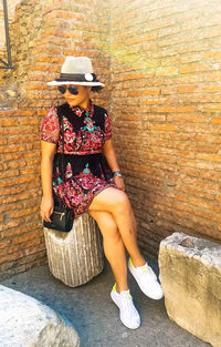 Young woman wearing hat sitting outdoors