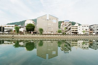 Reflection of buildings in lake against sky