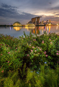 Scenic view of river by bridge against sky during sunset