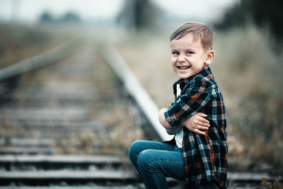 Portrait of boy standing on footpath