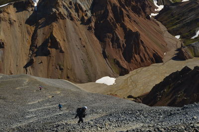 Panoramic view of people walking on rocky mountain