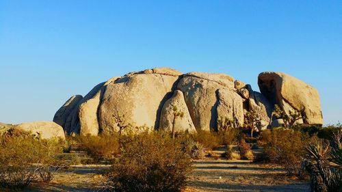 Rock formations on landscape against blue sky