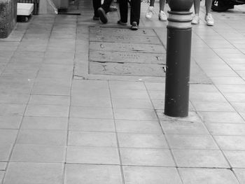 Low section of man standing on tiled floor