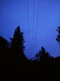 Low angle view of silhouette trees against sky