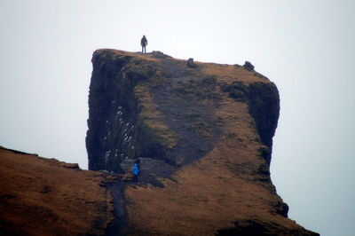 Low angle view of man standing on cliff