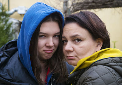 Teen girl and her mother hugging together outdoors