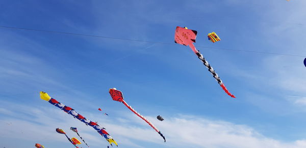 Low angle view of flags hanging against sky