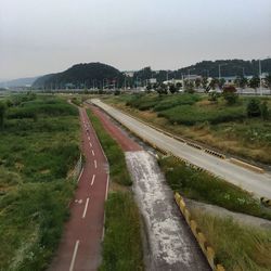 Road amidst landscape against sky in city