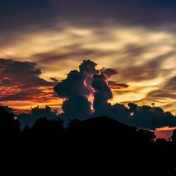 Silhouette of mountain against cloudy sky at sunset