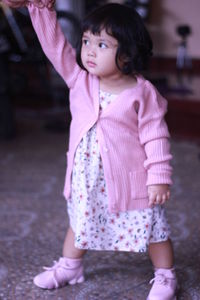 Full length of cute girl looking away