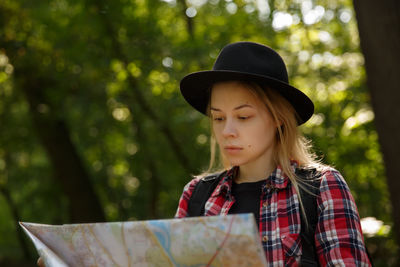 Portrait of young woman standing in forest