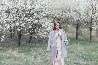 Beautiful girl in a dress walking in a blooming garden