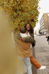 Happy woman standing in park during autumn