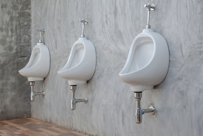 Toilet bowls against wall in bathroom