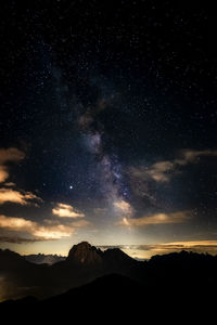 Scenic view of silhouette mountains against sky at night