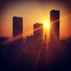 Silhouette cityscape against sky during sunset