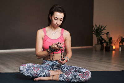 Young woman meditating alone with a yoga studio for yoga with beads