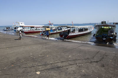 Boats moored at sea against clear sky