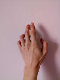 Close-up of hands against wall