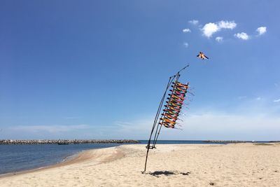 Lifeguard hut on beach against blue sky