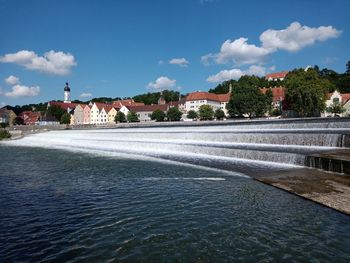 View of swimming pool by buildings against sky