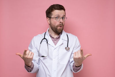 Mid adult man standing against colored background
